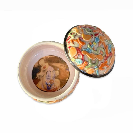 Orange Lidded Container With Clown Image Inside